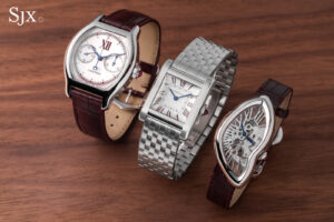 Three platinum Cartier Prive Les Opus watches arranged side by side: the Tank Normale on the left, the Tortue Chronographe Monopoussoir in the middle, and the Crash Squelette on the right with burgundy printing