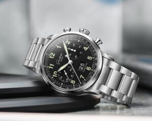 Two Glashuette Original Senator Chronograph watches side by side: the classic silver-grain model on the left and the black-lacquer Navigator pilot variant on the right, both in stainless steel