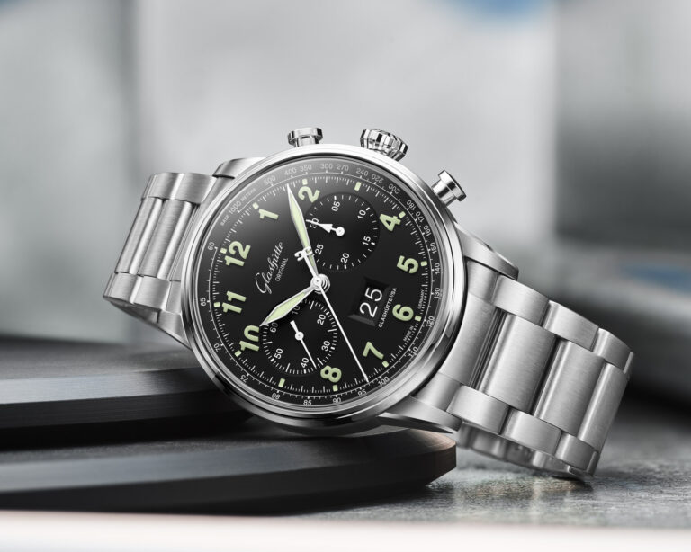 Two Glashuette Original Senator Chronograph watches side by side: the classic silver-grain model on the left and the black-lacquer Navigator pilot variant on the right, both in stainless steel