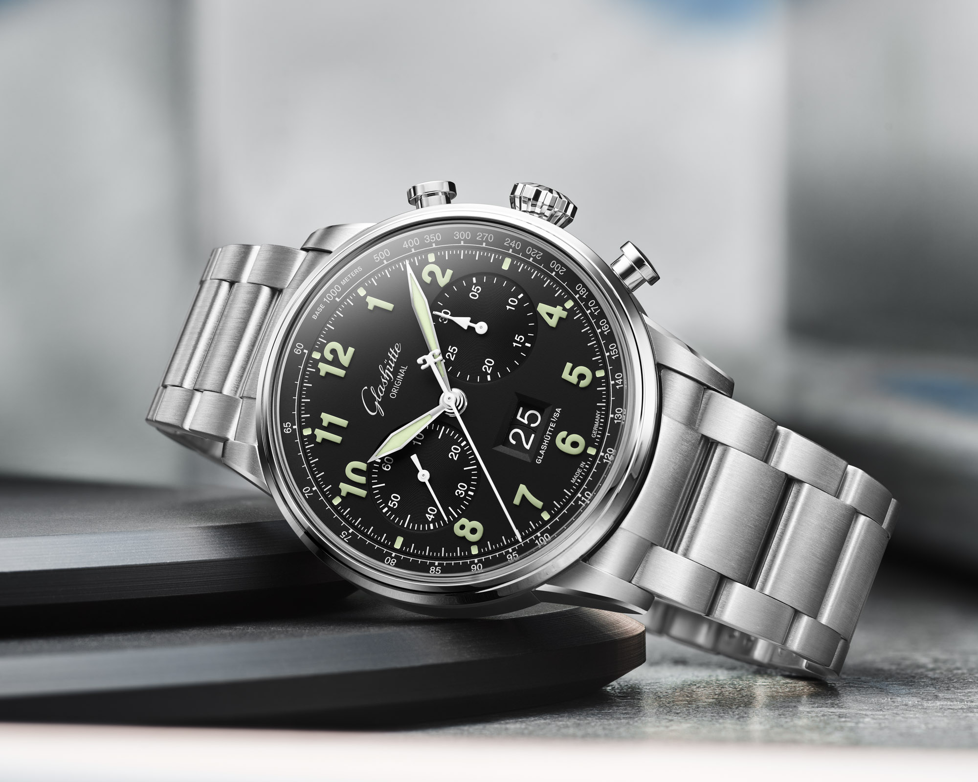 Two Glashuette Original Senator Chronograph watches side by side: the classic silver-grain model on the left and the black-lacquer Navigator pilot variant on the right, both in stainless steel