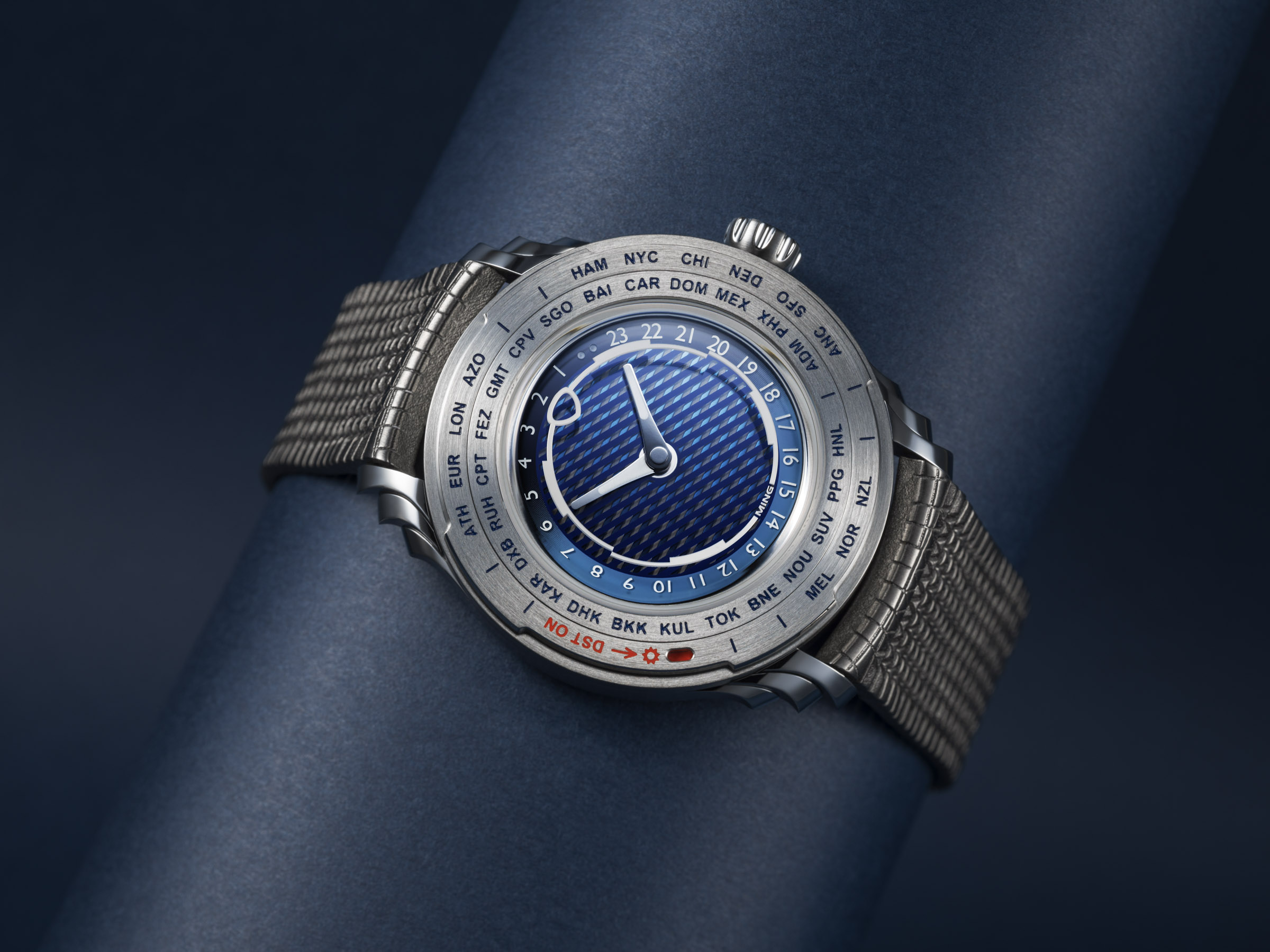 Ming 57.05 Comet worldtimer on titanium Polymesh bracelet showing the blue multi-layer dial and DST bezel